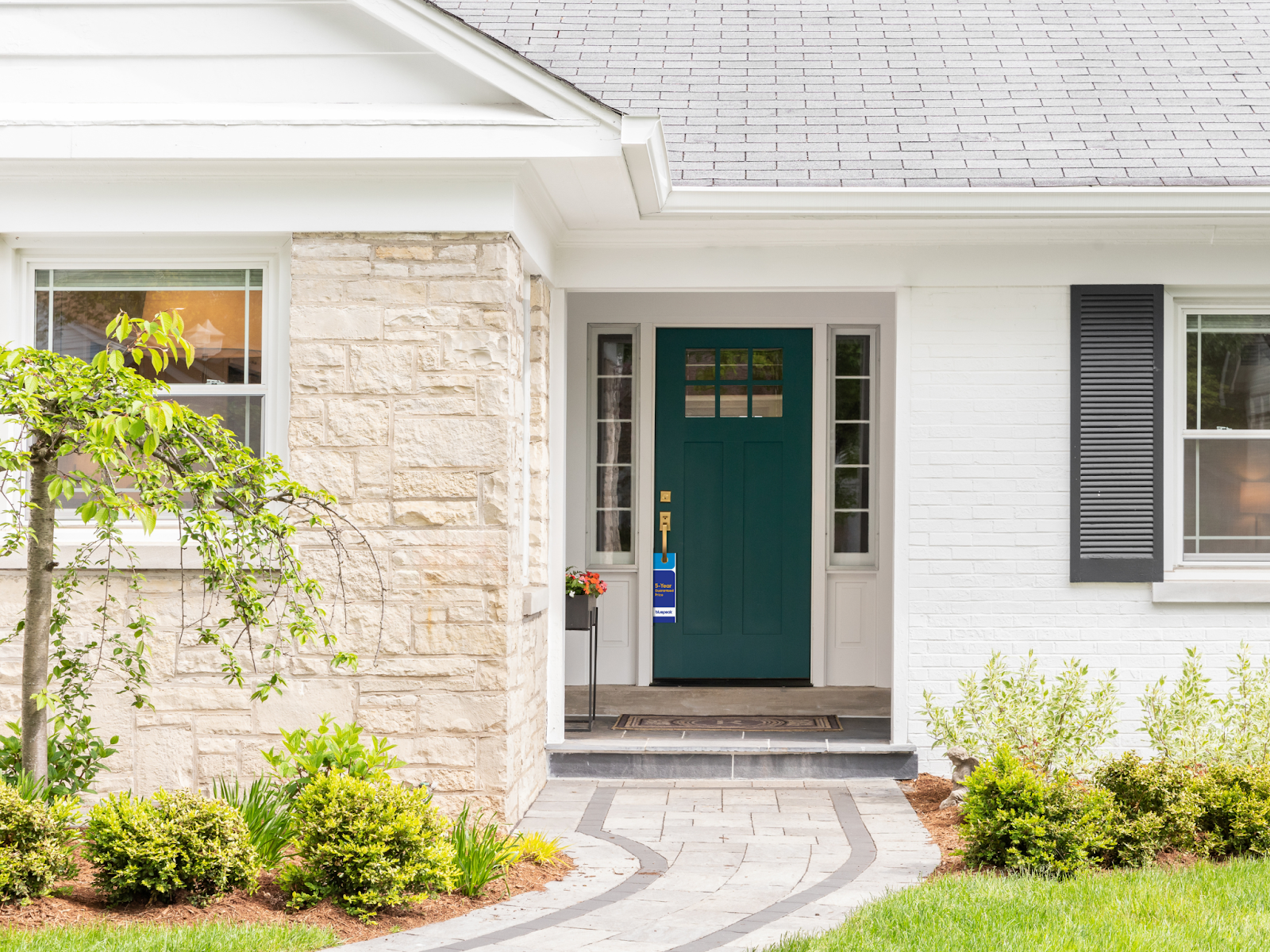 Front porch of a home with a door hanger visible on the front door, showcasing effective door hanger distribution for targeted marketing