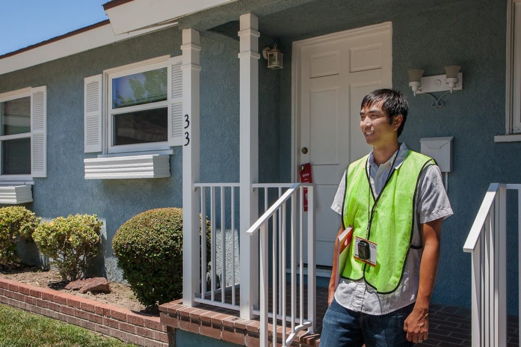 A uniformed man distributes door hangers